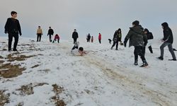 Çocuklar tepsi ve plastik bidonlarla kayarak eğlendi