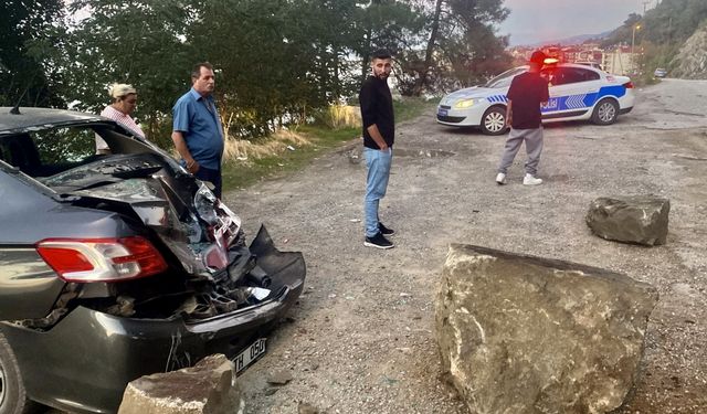 Yamaçtan kopan kaya parçası park halindeki otomobilin üzerine düştü