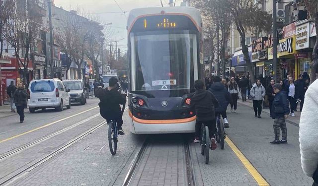 Tramvayın arkasına tutunan bisikletli çocuklar canlarını tehlikeye attı